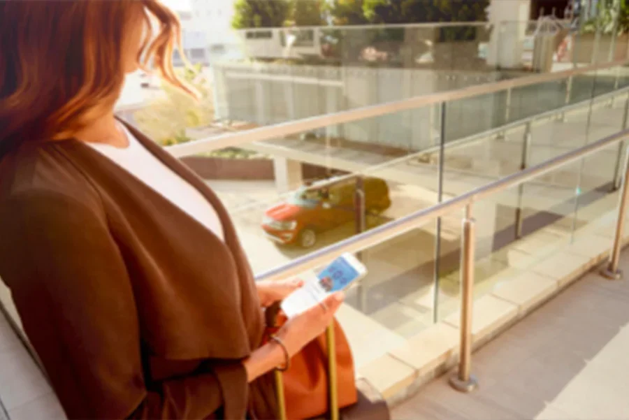 image of a woman on an overpass walkway with a smartphone in her hands