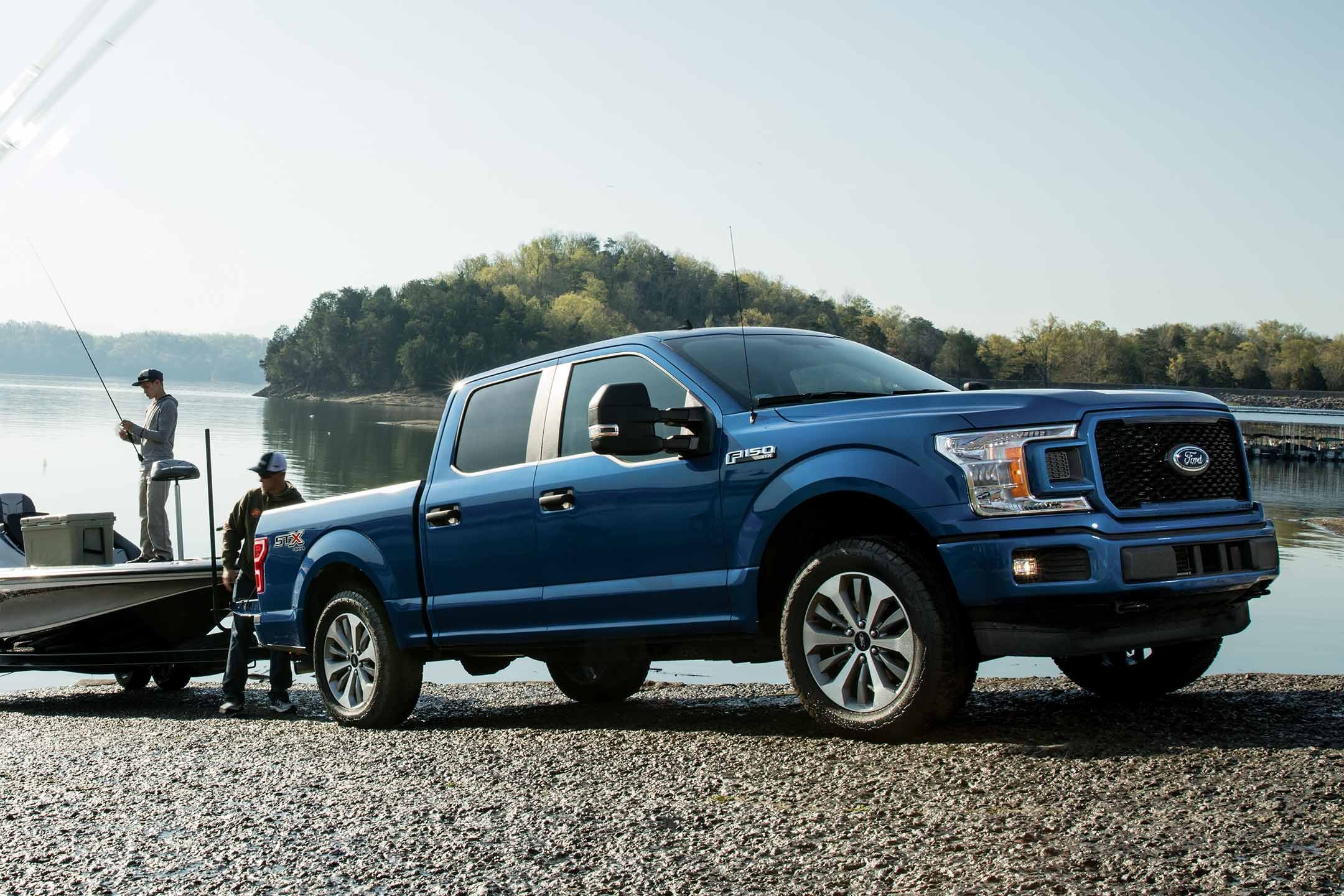 image of a blue Ford truck with a boat